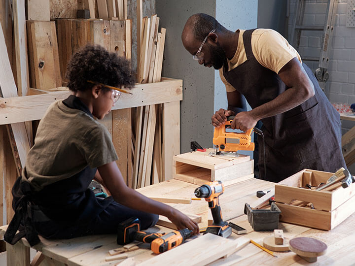 Power Tools and Outdoor Power Equipment Testing with a father and son woodworking with a jigsaw and power drill