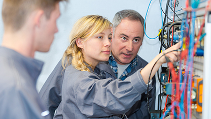 And image of two people - men and a woman - working with concentration in an industrial setting